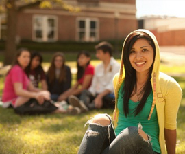 girl sitting outside on campus with friends